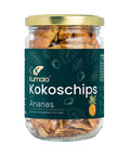 Glas mit Kumaio Kokoschips, verfeinert mit Ananasgeschmack, mit dunkelgrünem Etikett.